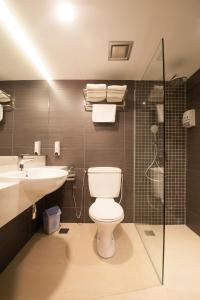 a bathroom with a toilet and a sink and a shower at Hotel Malaysia in George Town