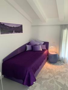 1 dormitorio con cama morada y manta morada en Villa Il Bacio del Sole, en Verona