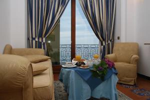 a living room with a table and two chairs at Hotel Belvedere in Conca dei Marini