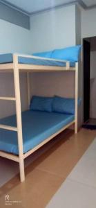 2 beliches num quarto com almofadas azuis em 4C’s Room Rental, Apartments, Hotel and Transient em Calapan