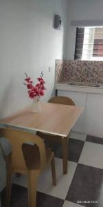 uma mesa de madeira com cadeiras e um vaso com flores em 4C’s Room Rental, Apartments, Hotel and Transient em Calapan