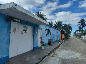 a blue building with a shark painted on the side of it at Chalé do Tio Beto - Caraguatatuba in Caraguatatuba