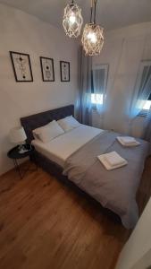 ein Schlafzimmer mit einem großen Bett und einem Kronleuchter in der Unterkunft Apartman SATO in Brčko
