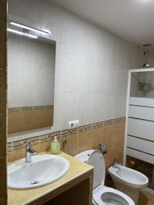 ein Badezimmer mit einem Waschbecken, einem WC und einem Spiegel in der Unterkunft Casa Oceano - 2 Bedroom Apartment in San Fernando