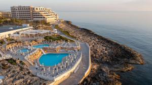 a large body of water with a beach at Radisson Blu Resort, Malta St. Julian's in St. Julianʼs