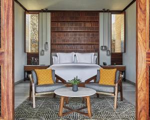 CihuatlánにあるFour Seasons Resort Tamarindo, Méxicoのベッドルーム1室(ベッド1台、椅子2脚、テーブル付)