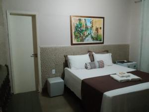Säng eller sängar i ett rum på Pousada da Gi Suítes e Turismo