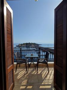 a balcony with a table and chairs and the ocean at atoll 'Paris-Alexandre' in Gythio