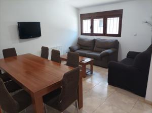 sala de estar con mesa de madera y sofá en Casa Dinorural, en El Castellar