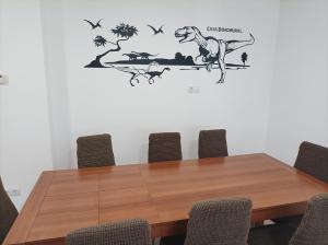 einen Konferenztisch mit einem Dinosaurier an der Wand in der Unterkunft Casa Dinorural in El Castellar