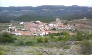 eine Stadt auf einem Hügel mit Bergen im Hintergrund in der Unterkunft Casa Dinorural in El Castellar