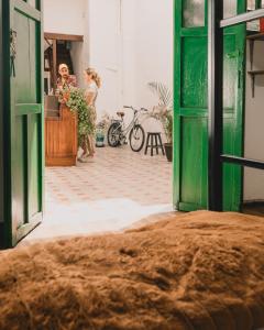 two women standing in a room with a green door at Wild Monkey Hostel in Cuenca