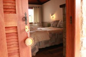 a bedroom with a bed and a clock on the door at Pousada Jardim da Luz in Visconde De Maua