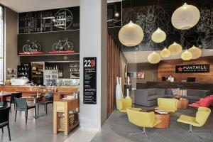 un restaurant avec des chaises jaunes et un bar dans l'établissement Punthill Norwest, à Baulkham Hills