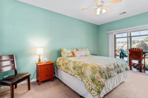 a bedroom with a bed and a chair and a window at Coral Reef Retreat in Sunset Beach
