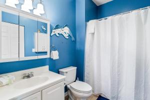 a blue bathroom with a toilet and a sink at Coral Reef Retreat in Sunset Beach