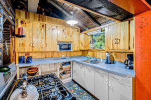 a kitchen with wooden cabinets and a sink and a stove at Minerva's Log Cabin Gem in Minerva