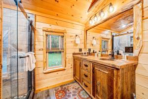 a log cabin bathroom with a sink and a shower at Minerva's Log Cabin Gem in Minerva