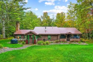 a log cabin in the woods with a yard at Minerva's Log Cabin Gem in Minerva