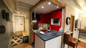 uma cozinha com armários vermelhos e um balcão preto em Paris Coeur Saint Germain Standing em Paris
