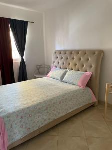 a bedroom with a bed with pink and blue pillows at Apartamentos Avenida in Praia