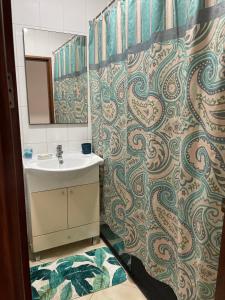La salle de bains est pourvue d'un lavabo et d'un miroir. dans l'établissement Apartamentos Avenida, à Praia