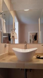 a bathroom with a white sink and a mirror at Hotel Medrano Temáticas and Business Rooms Aguascalientes in Aguascalientes