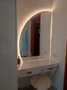 baño con espejo y silla frente a un lavabo en atoll 'Paris-Alexandre', en Gythio