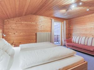a bedroom with two beds and a red couch at Glonersbühelhof Top 1 in Westendorf