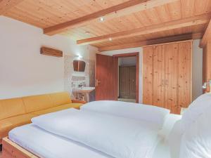 a bedroom with a white bed and a couch at Glonersbühelhof Top 2 in Westendorf