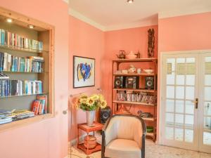 ein Zimmer mit einem Stuhl und einem Bücherregal mit Büchern in der Unterkunft Villa Mesal in Sarrecave