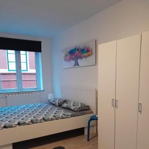 1 dormitorio con 1 cama y un árbol en la pared en Annalisa Guest House Centrum, en Enschede