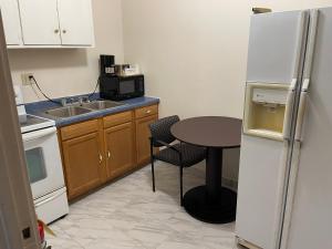 a small kitchen with a table and a refrigerator at Village Inn Green Bay in Green Bay