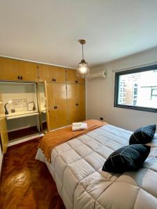 een slaapkamer met een groot bed met kussens erop bij TREJO Nueva Córdoba - A metros del Hospital Allende y Oulton in Cordoba