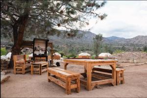 a picnic table and benches with a view of a mountain at SoCal Camping in Kernville
