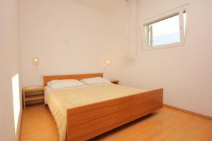 Schlafzimmer mit einem Bett und einem Fenster in der Unterkunft Apartments with a parking space Zavala, Hvar - 8912 in Zavala