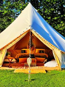 uma tenda azul e branca com sofás em CAYORETREAT LUXURY BELL TENT em Clodock