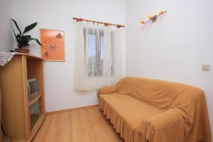 ein Wohnzimmer mit einem Sofa und einem TV in der Unterkunft Apartment Ilovik 8069a in Ilovik