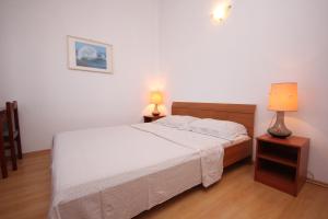 ein Schlafzimmer mit einem Bett und zwei Lampen an Tischen in der Unterkunft Apartments by the sea Ilovik, Losinj - 8069 in Ilovik
