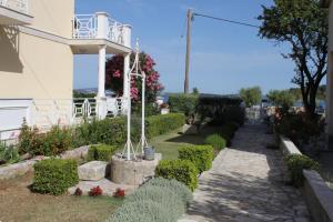 a garden in front of a building with a balcony at Triple Room Pasman 8223a in Pašman