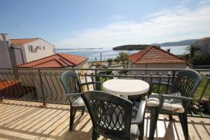 a patio with a table and chairs on a balcony at Triple Room Pasman 8223e in Pašman