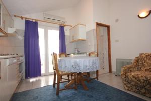 a kitchen with a table and chairs in a room at Apartments with parking space Kraj, Pasman - 8502 in Tkon