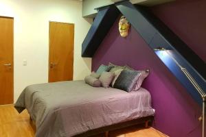 1 dormitorio con 1 cama con pared morada en Reforma Center Great Mexico City View Condo, en Ciudad de México