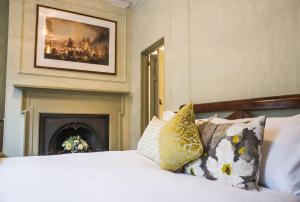 a bedroom with a bed with pillows and a fireplace at 38 St Giles in Norwich