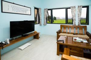 a living room with a large flat screen tv at Chin-Lan B&B in Zhuangwei