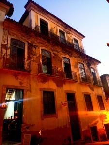 um edifício antigo com uma varanda em cima em Hostel L B em São Luís