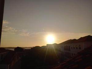 um pôr-do-sol sobre uma cidade com o sol no céu em Hostel L B em São Luís