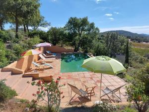 プラン・ド・ラ・トゥールにあるLavish Holiday Home in Le Plan de la Tour with Swimming Poolのパラソルと椅子付きのプール、スイミングプールを提供しています。