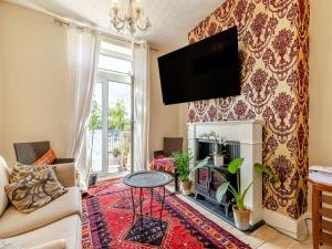 uma sala de estar com lareira e uma televisão na parede em 6 Fairfield Road em Buxton