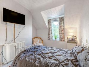 um quarto com uma cama e uma televisão de ecrã plano em 6 Fairfield Road em Buxton